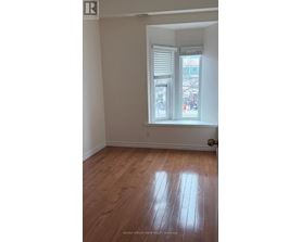 A room with a window and wooden flooring.