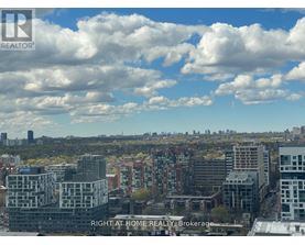 A cityscape with buildings and a cloudy sky.
