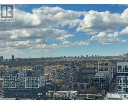 A cityscape with buildings and a cloudy sky.