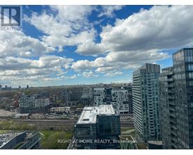 A cityscape with buildings and a cloudy sky.