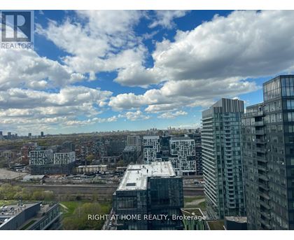 A cityscape with buildings and a cloudy sky.