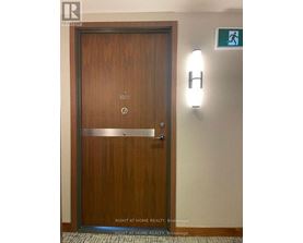 A wooden door with a handle and a sign above it.