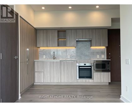 A modern kitchen with a marble backsplash and stainless steel appliances.
