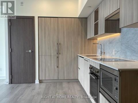 A modern kitchen with wooden cabinets and stainless steel appliances.