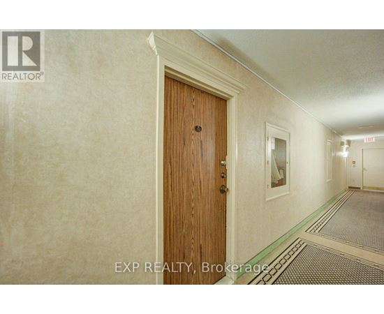 A hallway with a wooden door and a green stripe on the floor.