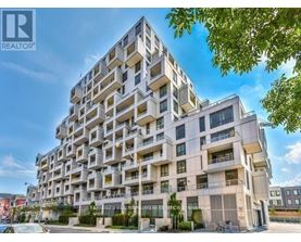 A tall residential building with balconies and multiple windows.