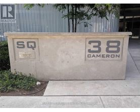A concrete structure with the letters "SQ" and the number "38 Cameron" on it.