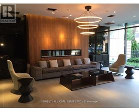 A modern living room with a brown couch and a wooden wall.