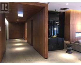 A hallway with wood paneling and a black sofa.