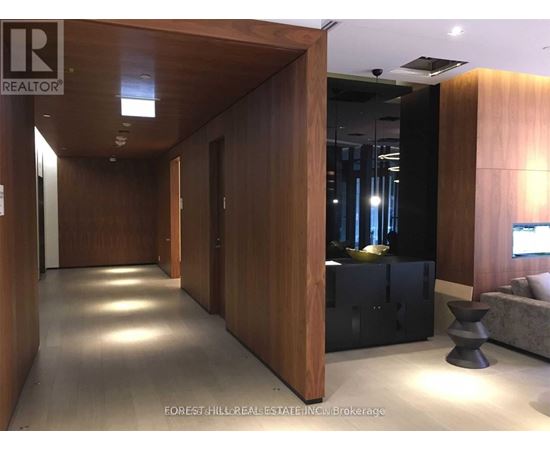 A hallway with wood paneling and a black sofa.