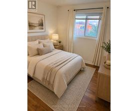 A bedroom with a large bed and a window with curtains.