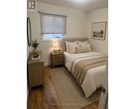 A bedroom with a bed, nightstand, and lamp.
