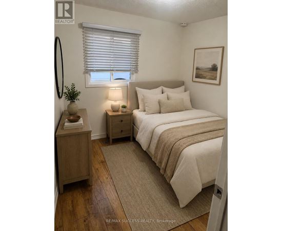 A bedroom with a bed, nightstand, and lamp.