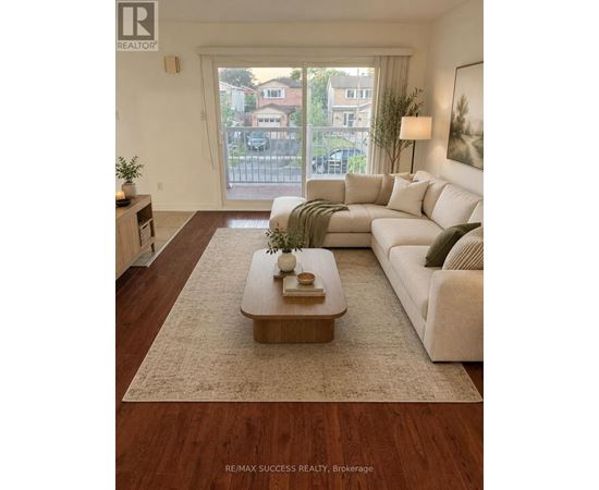 A living room with a white couch and a coffee table in front of a large window.