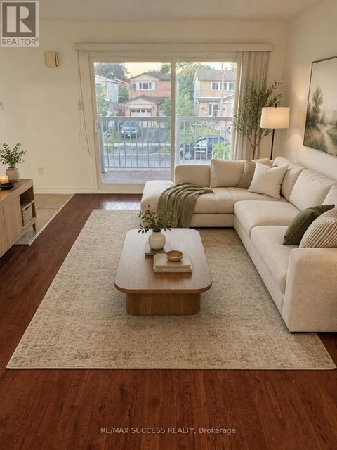 A living room with a white couch and a coffee table in front of a large window.