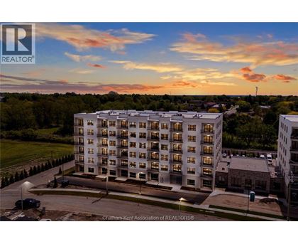 A large apartment building with a parking lot in front of it.