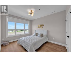 A bedroom with a large bed and a window overlooking a parking lot.