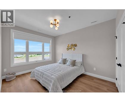 A bedroom with a large bed and a window overlooking a parking lot.