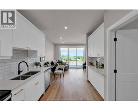 A modern kitchen with white cabinets and a large window.