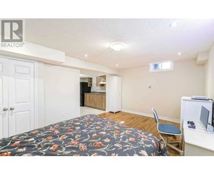 A bedroom with a bed, desk, and chair.