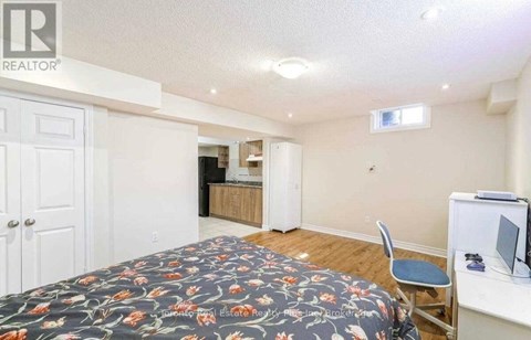 A bedroom with a bed, desk, and chair.