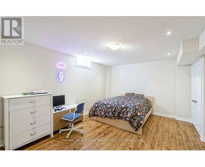 A bedroom with a bed, desk, and chair.