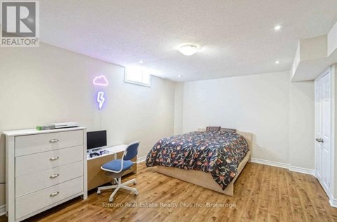 A bedroom with a bed, desk, and chair.
