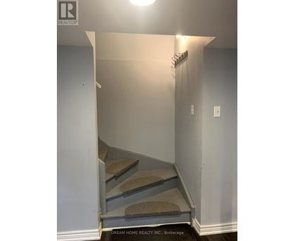 A hallway with a staircase leading to the second floor.