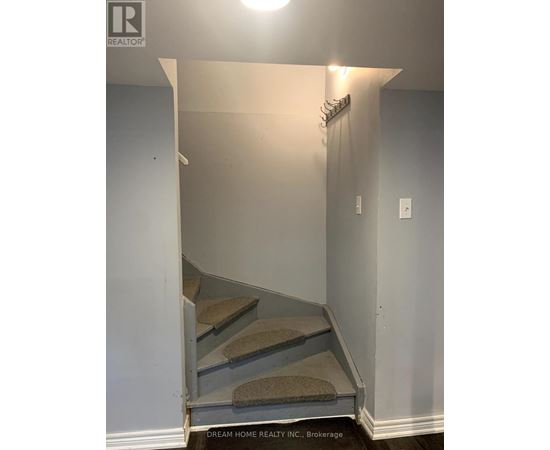 A hallway with a staircase leading to the second floor.