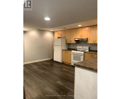 A kitchen with wooden cabinets and a white fridge.