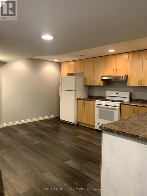 A kitchen with wooden cabinets and a white fridge.