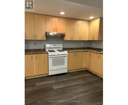A kitchen with wooden cabinets and a white stove top oven.