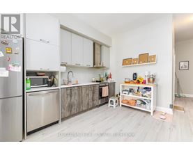 A kitchen with white cabinets and a refrigerator.
