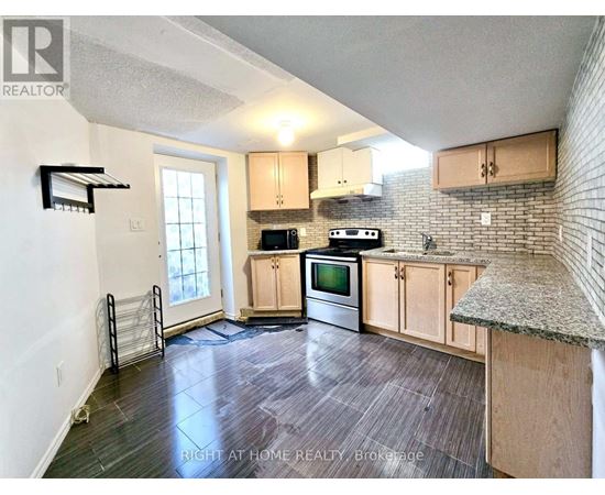A kitchen with wooden cabinets and a granite countertop.