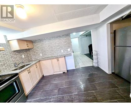 A kitchen with a stove top oven and a refrigerator.