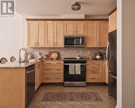 A kitchen with wooden cabinets and a rug on the floor.