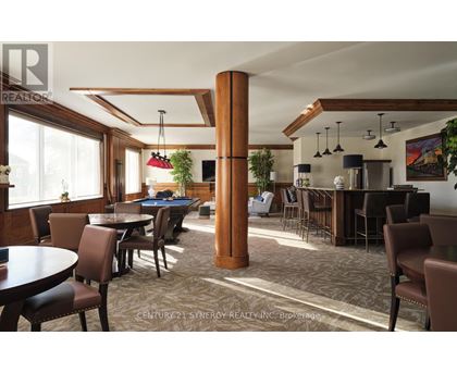 A room with a pool table and a bar area.