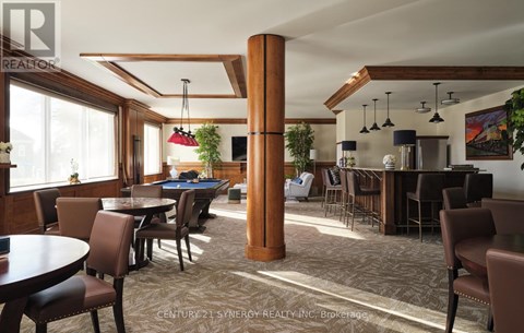 A room with a pool table and a bar area.