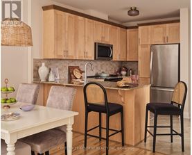 A kitchen with wooden cabinets and a white table.