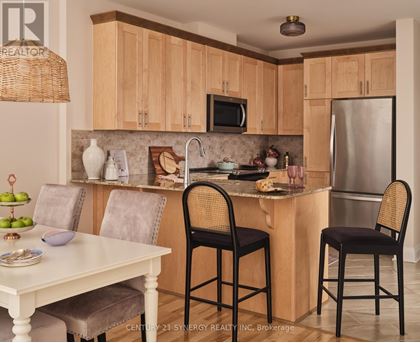 A kitchen with wooden cabinets and a white table.