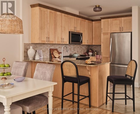 A kitchen with wooden cabinets and a white table.