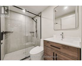 A modern bathroom with a walk-in shower and a double sink vanity.