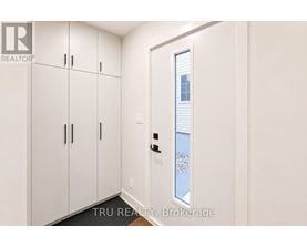 A white door with a window in the middle of a white wall.