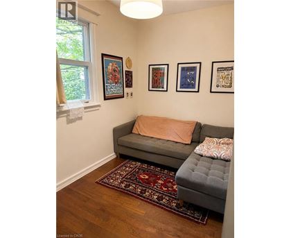 A living room with a grey couch and a rug.