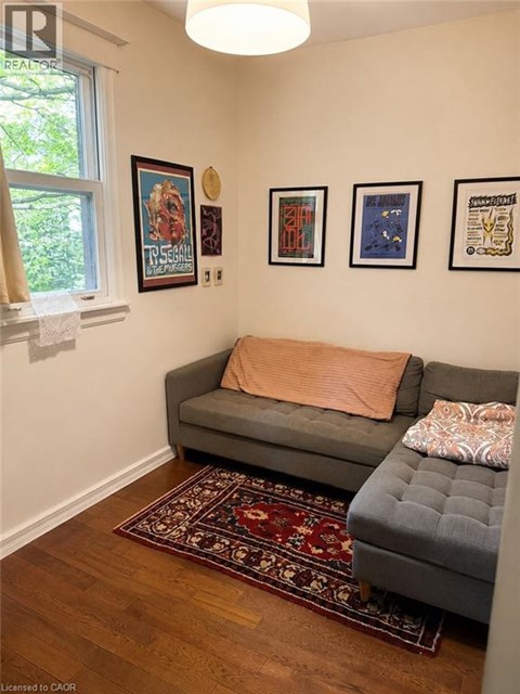 A living room with a grey couch and a rug.
