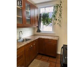 A kitchen with brown cabinets and a black dishwasher.