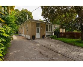A small house with a driveway in front of it.