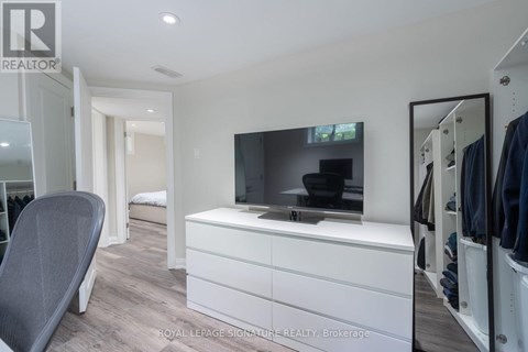 A modern bedroom with a white dresser and a flat screen TV.