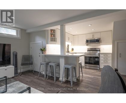 A modern kitchen with white cabinets and stainless steel appliances.