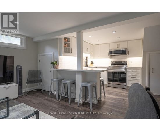 A modern kitchen with white cabinets and stainless steel appliances.